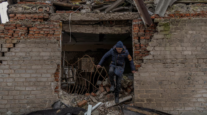 Mykola, de 76 años, busca leña en un edificio dañado por ataques militares rusos, en medio del ataque de Rusia a Ucrania, en Pokrovsk, región de Donetsk. (Infobae)